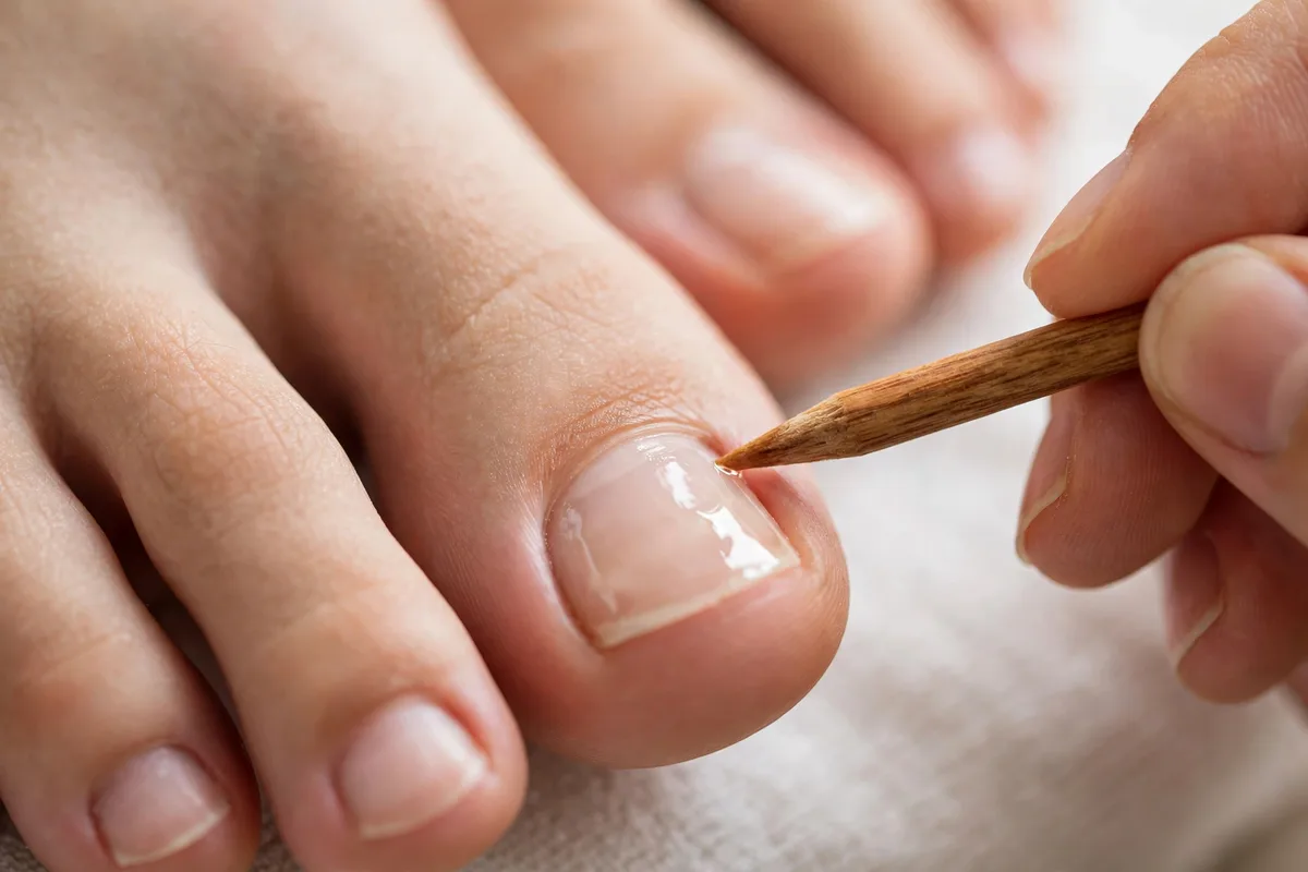 Cuticles being gently pushed back with cuticle oil — pedicure step 4